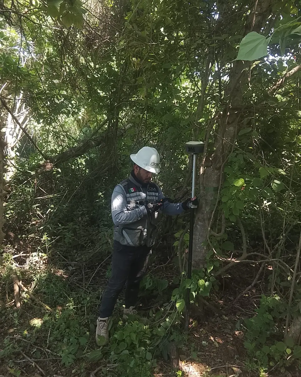 Receptor GNSS midiendo junto a un tronco y vegetación densa que obstruyen la señal satelital