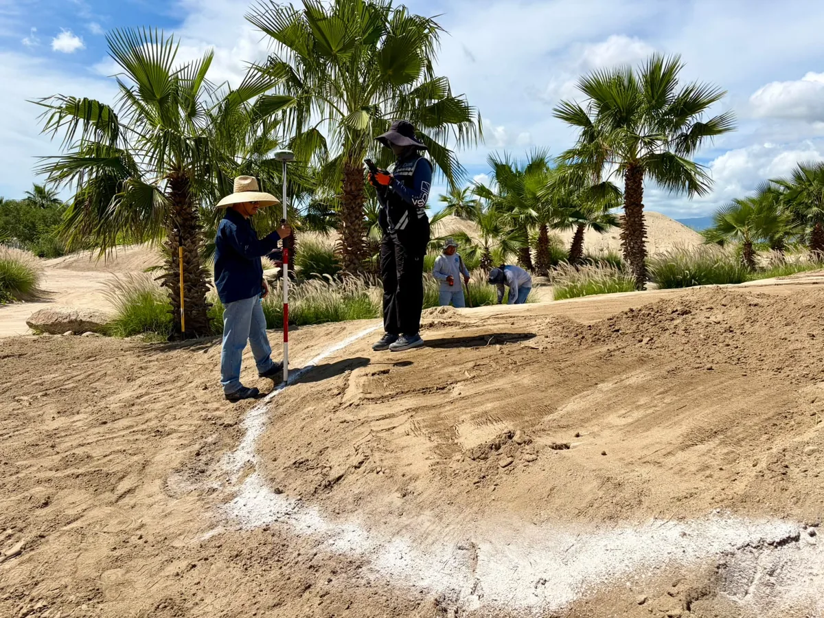 Topógrafo y auxiliar de CISA replanteando con receptor GNSS sobre el trazo marcado en obra